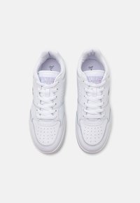 White leather sneakers with perforated toe, flat laces, padded collar, and multicolored logo on the side. Simple design and smooth texture.