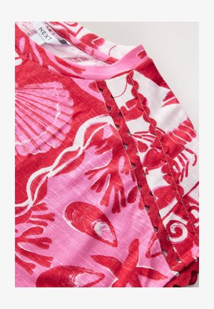 Rot- und rosa gemusterter Stoff mit Muschel- und Korallendesigns. Enthält gewellte Akzente und ein Halsauschnitt-Detail.