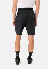 Pantalones cortos negros con un diseño liso, que cuentan con una cinturilla elástica ancha y un corte aerodinámico, fabricados con material ligero y transpirable.