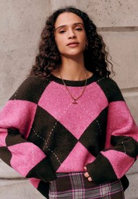 Großzügig geschnittener Pullover mit Rautenmuster in Pink und Dunkelbraun, mit gerippten Bündchen und rundem Ausschnitt. Strukturierter Strickstoff.