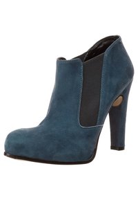 Sininen mokkanahkainen nilkkuri, jossa on korkea stiletto-korko, joustavat sivupaneelit ja pyöreä kärki. Suuret sileät pinnat, joissa on kontrastivärisiä mustia yksityiskohtia.