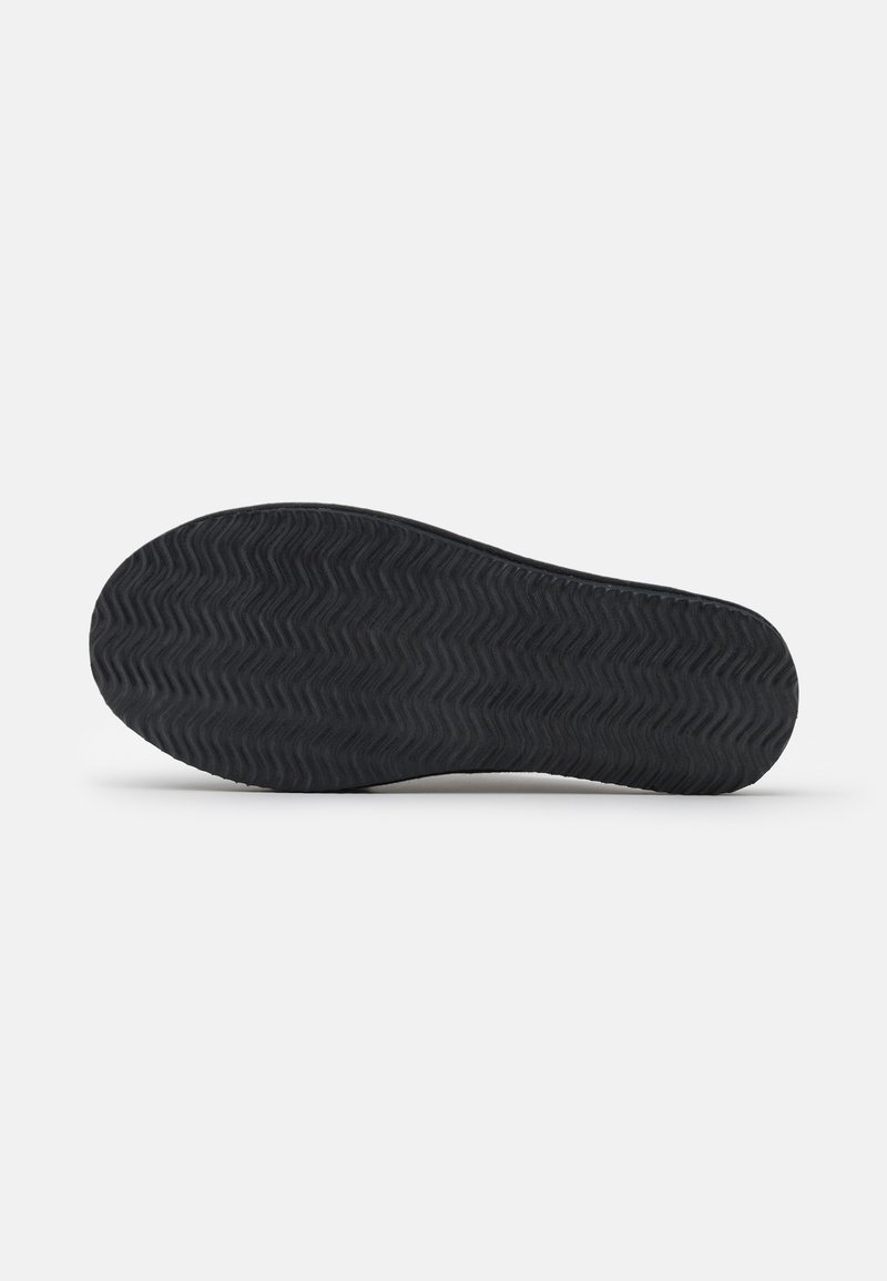 Suola di scarpa in gomma nera con un motivo a ondulato, profilo piatto e texture liscia. I bordi sono arrotondati; nessun marchio o segno visibile.