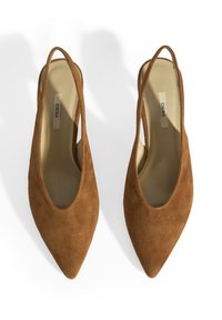 Talons slingbacks en suède brun avec un bout pointu et une doublure intérieure lisse. Présente une sangle fine et un design minimaliste.