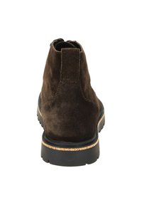 Stivali alla caviglia in suede marrone con superficie strutturata, pannelli laterali elasticizzati e suola in gomma con un accento in sughero attorno al bordo della suola.