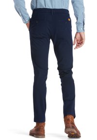 Námořnické bavlněné chinos kalhoty se slim fit, s dvěma zadními kapsami a hnědým koženým štítkem. Hladká textura a čisté linie.