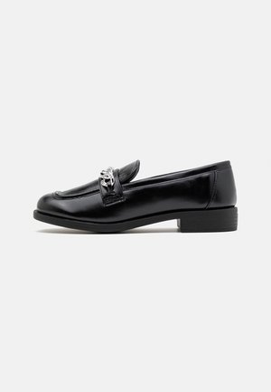 Zwarte leren loafer met lage hak, afgeronde neus en zilveren kettinkdetail op de band, zijaanzicht op een witte achtergrond.