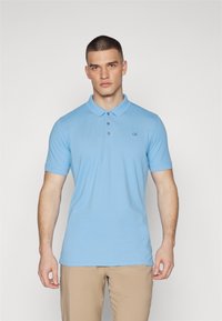 Svijetloplava polo majica od glatkog materijala, s ovratnikom s tri gumba, kratkim rukavima i malim logotipom na prsima.