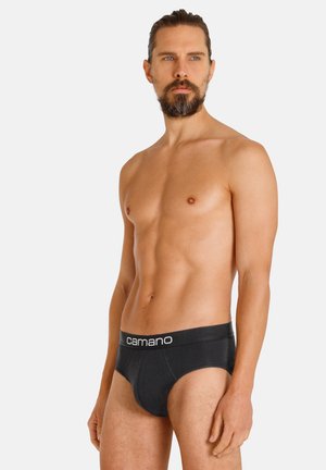Schwarze Baumwollslips mit einem Logobund, klassischem Schnitt, elastischem Bund und glatter Textur. Das Modell steht in neutraler Haltung.