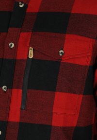 Rood en zwart geruit flanelhemd met een borstzak met rits, metalen knopen en een gestructureerde stof.