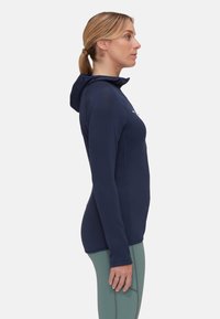 Granatowy hoodie z długimi rękawami i kieszenią z przodu. Posiada teksturowany materiał i dopasowany krój, zestawiony z jasnorozowym legginsami.