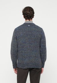 Pulover tricotat în nuanțe de albastru, verde și gri; guler rotund; model texturat, tricot gros; caracterizat de o etichetă logo pe spatele gulerului.