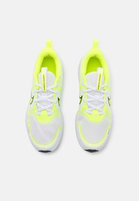 Neon yellow and white sneakers with mesh upper, contrasting black accents, and white laces; features a prominent brand label on the tongue.