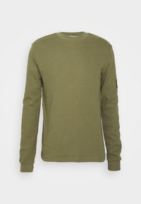 Olivgrön långärmad t-shirt med ribbat mönster, rund halsringning och åtsittande manschetter. Har en liten logotyp på ärmen.