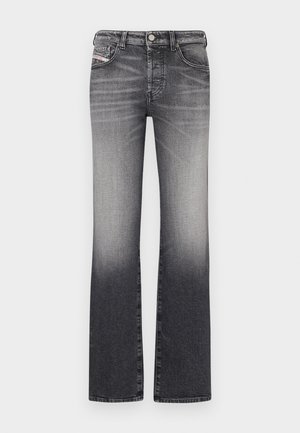 Razširjene kavbojke v degradaciji od črne do sive. Opremljene z petimi žepi, zapiranjem z gumbom in zadrgo ter pasom za pas. Denimska tkanina z gladko teksturo.