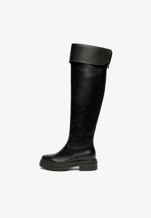 Bottes noires arrivant jusqu'au genou, en cuir lisse, avec un revers plié, un bout arrondi et une semelle en caoutchouc épaisse avec une texture antidérapante.