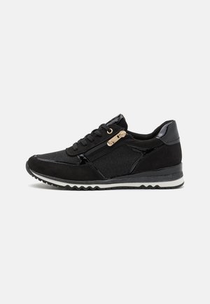 Black athletic shoes with a mix of suede and textile materials, featuring a side zipper, round toe, and a white rubber sole.