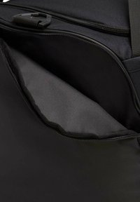 Zwarte stoffen tas met een ritsopening, toont een gladde binnenvoering en een getextureerde buitenkant. Bevat een stevige rits en minimale hardware.