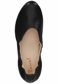 Chaussure plate en cuir noir avec une finition lisse, bord élastique, design à bout rond et semelle intérieure de couleur claire arborant une marque.