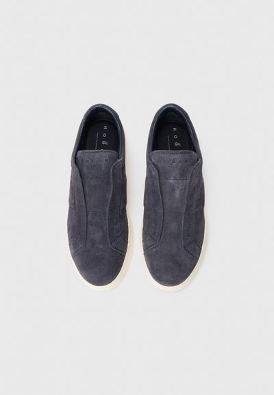 Pair of dark gray suede slip-on sneakers with white soles, minimal stitching, and brand name embossed on the upper front.
