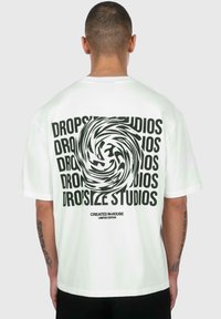 Weißes T-Shirt mit einem großen schwarzen runden Grafik und "DROPSIZE STUDIOS", das mehrmals aufgedruckt ist. Kurzärmlig, lockerer Schnitt, aus Baumwolle.