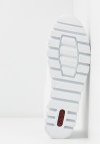 Sneaker bianco con suola in gomma testurizzata e scanalata, colletto imbottito e accento del logo rosso sul lato della suola.