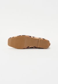 Sola di scarpa piatta con stampa leopardata, con fondo in gomma beige e linee di presa testurizzate. Presenta una forma arrotondata e leggermente allungata.