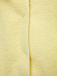 Φλις μπουφάν σε απαλό κίτρινο ύφασμα, με υφή, λεία άκρα και ανοιχτόκίτρινα κουμπιά κατά μήκος του εμπρόσθιου κλεισίματος.