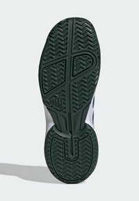 Semelle en caoutchouc de sneaker présentant un motif en chevrons, principalement de couleur vert foncé avec des rainures texturées et un logo Adidas dans la zone du talon.