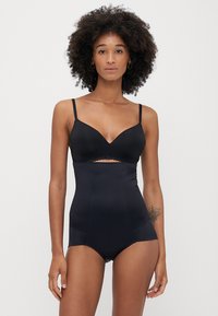 Bodysuit preto feito de um tecido liso, com um design recortado e alças ajustáveis, com uma cintura alta e um discreto detalhe de rendas.