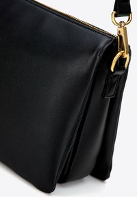 Borsa a tracolla nera in pelle con finitura strutturata, hardware dorato e chiusura con zip. Presenta una forma piatta e ben definita.