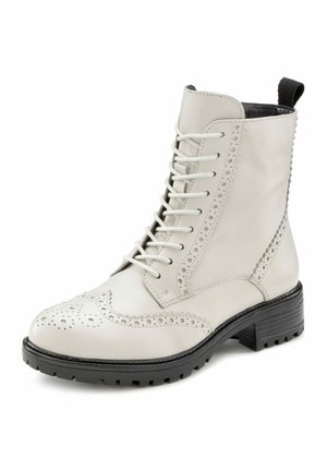 White leather ankle boot with lace-up design, brogue detailing, round toe, and textured black rubber sole for traction.