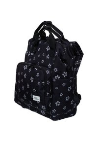 Mochila de tela negra con un patrón floral en blanco, múltiples bolsillos, dos asas y correas ajustables para mayor versatilidad.