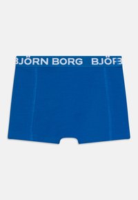 Blå boxershorts laget av myk stoff, med en hvit elastisk midjebånd med "BJÖRN BORG" logo, og en tettsittende passform uten mønster.