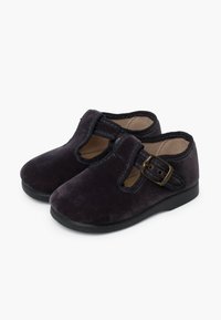 Scarpe in velluto viola scuro con design a T, fibbia regolabile e suole in gomma nera, caratterizzate da una texture liscia e una forma arrotondata.