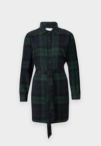 Robe chemise à carreaux verts et noirs en tissu, dotée d'un devant à boutons, de longues manches et d'un design à taille nouée.