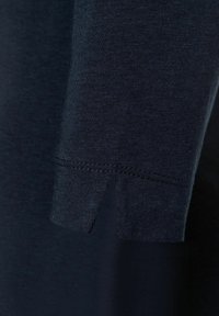 Dunkelblaues Langarmshirt mit geradem Schnitt und Seitenschlitz am Ärmelabschluss. Hergestellt aus glattem, weichem Stoff, der feine Nähte zeigt.
