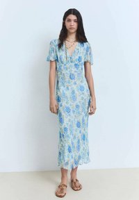 Blumenkleid in Hellblau mit kurzen, gerafften Ärmeln und einem V-Ausschnitt. Es hat eine fließende Silhouette und zarte blaue Rosenmuster.