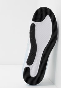 Nike kengät vaaleansinisen yläosan, mustan kumisen pohjan, valkoisen välikorokkeen ja reikäkuvioinnin ilmanvaihdolle. Korostettu logomuotoilulla.