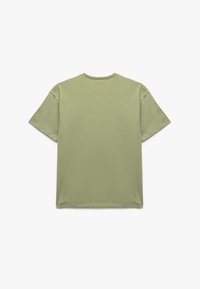 Camiseta de manga corta en verde oliva claro, hecha de algodón suave con un cuello redondeado y un corte relajado, textura suave, sin patrones visibles.