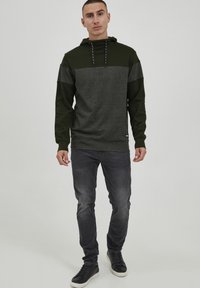 Hoodie in donkergroen en grijs; heeft een contrasterend kleurblokontwerp, een trekkoord, ribgebreide manchetten en een relaxte fit.