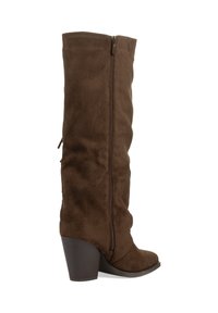 Botas de ante marrón por encima de la rodilla con cremallera lateral, punta redondeada y tacón grueso marrón. La textura parece suave y lisa.