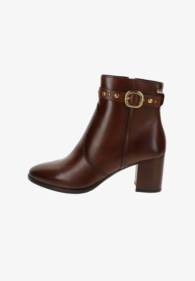 Botín de cuero marrón hasta el tobillo con tacón bloque, hebilla decorativa de oro y tachuelas en la correa, cierre lateral con cremallera.