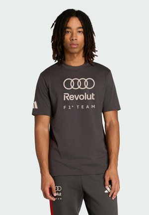 Grijs T-shirt met korte mouwen en een ronde hals, met witte Audi-ringen en "Revolut F1 TEAM" gedrukt op de voorkant. Gladde stof, losse pasvorm.
