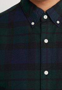 Camicia a quadri verde e navy con colletto a button-down, dotata di bottoni bianchi e realizzata in un cotone textured.