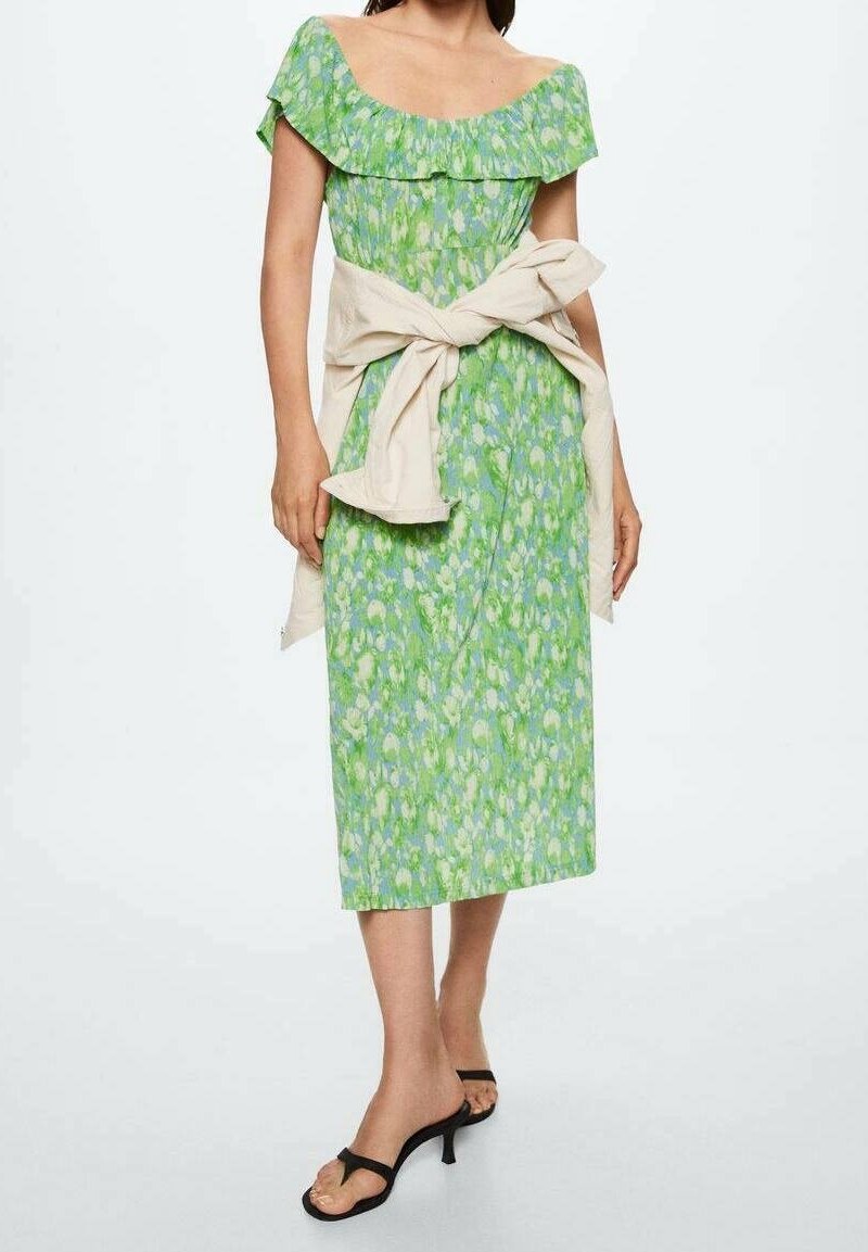 Robe midi à imprimé floral vert avec volants décolletés, taille cintrée et ceinture neutre. Présentée avec des sandales à lanières noires.