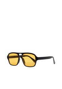 Occhiali da sole neri con montatura quadrata e lenti gialle. La montatura presenta una texture sottile, con un design minimalista e senza branding visibile.