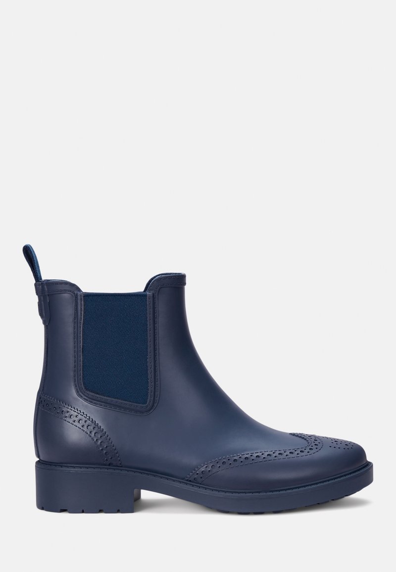 Botte Chelsea en caoutchouc bleu marine avec panneaux latéraux élastiques, détails brogue, tirette et un talon bloc robuste. Texture lisse sur l'ensemble.
