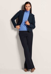 Navy blazer met subtiele structuur, gecombineerd met een lichtblauwe turtleneck en donkere broeken, met een soepele textuur en een op maat gemaakte pasvorm.