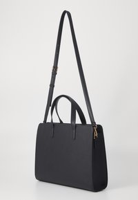 Sac à main synthétique noir avec une forme rectangulaire structurée, deux poignées supérieures, une longue sangle ajustable et un design minimaliste.