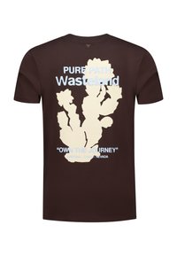 Brown cotton t-shirt featuring a large cream cactus graphic and blue text reading "PURE PATH Wasteland" and "OWN THE JOURNEY."